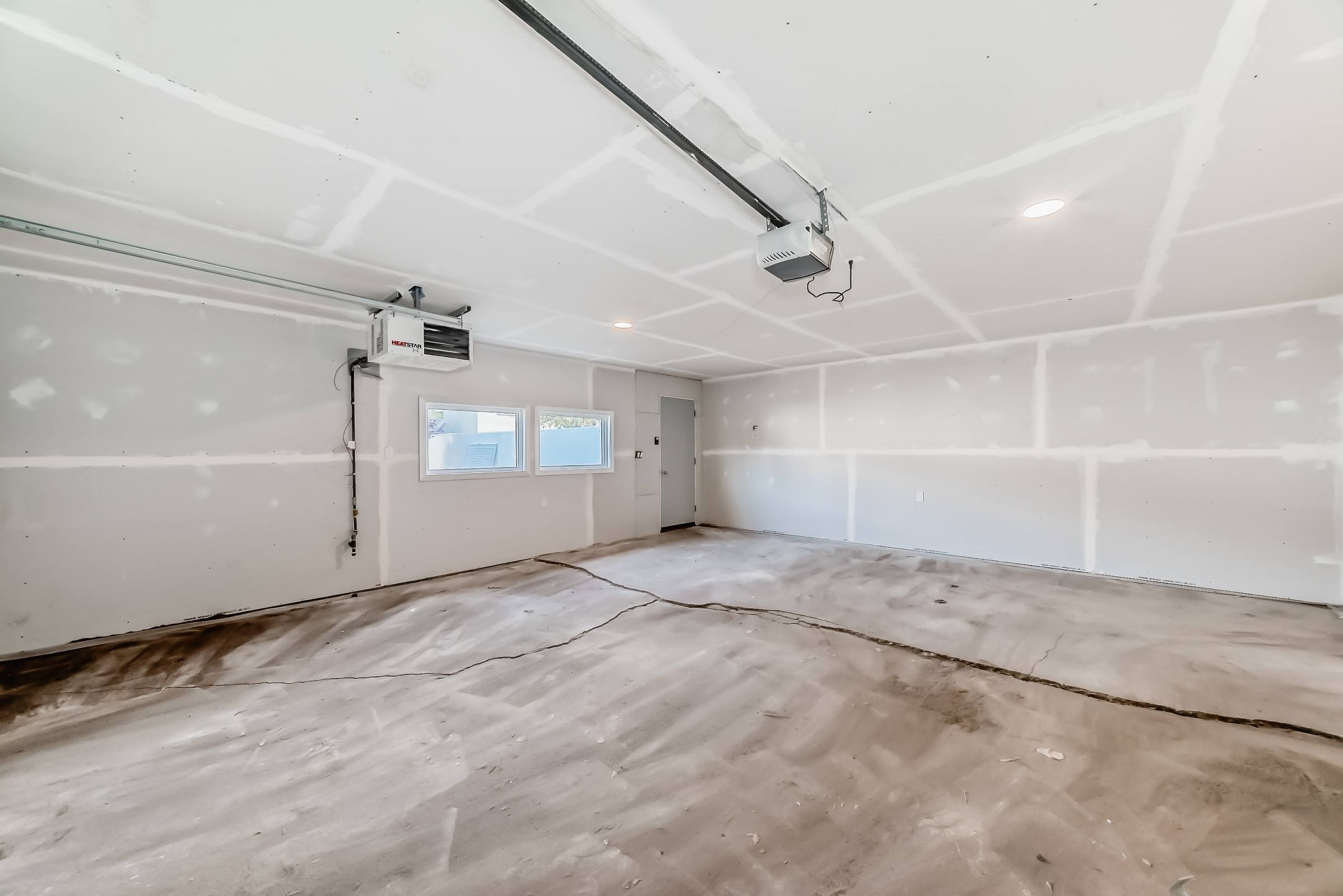 A room with white walls and a window is under construction.